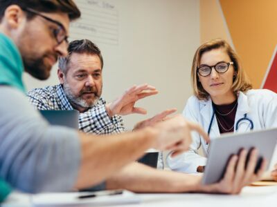 Doctors all reviewing a tablet computer